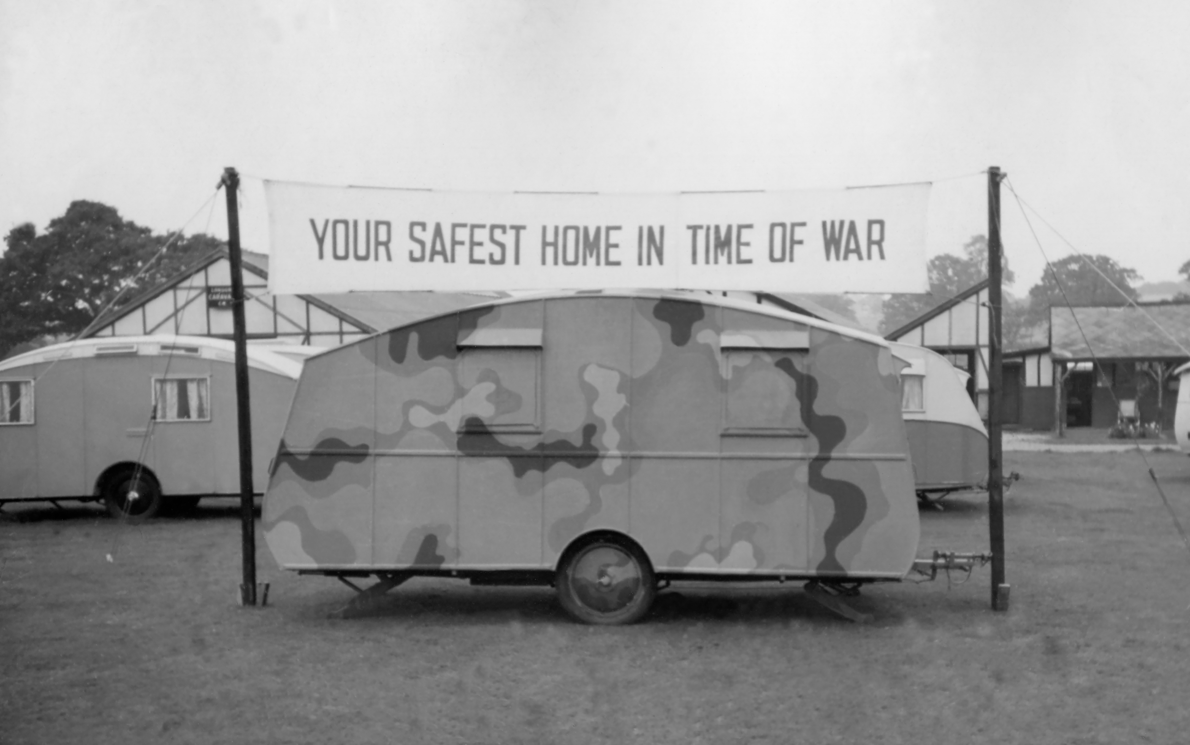 Camouflaged caravan under the banner "Your safest home in war"